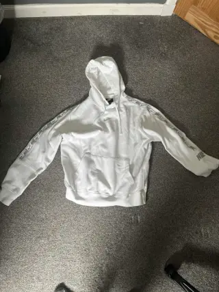 The original phone photo of a hoodie on a hanger